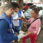 Médico uniformizado medindo a glicose de uma mulher.