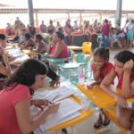 Mulher matriculando criança na escola municipal