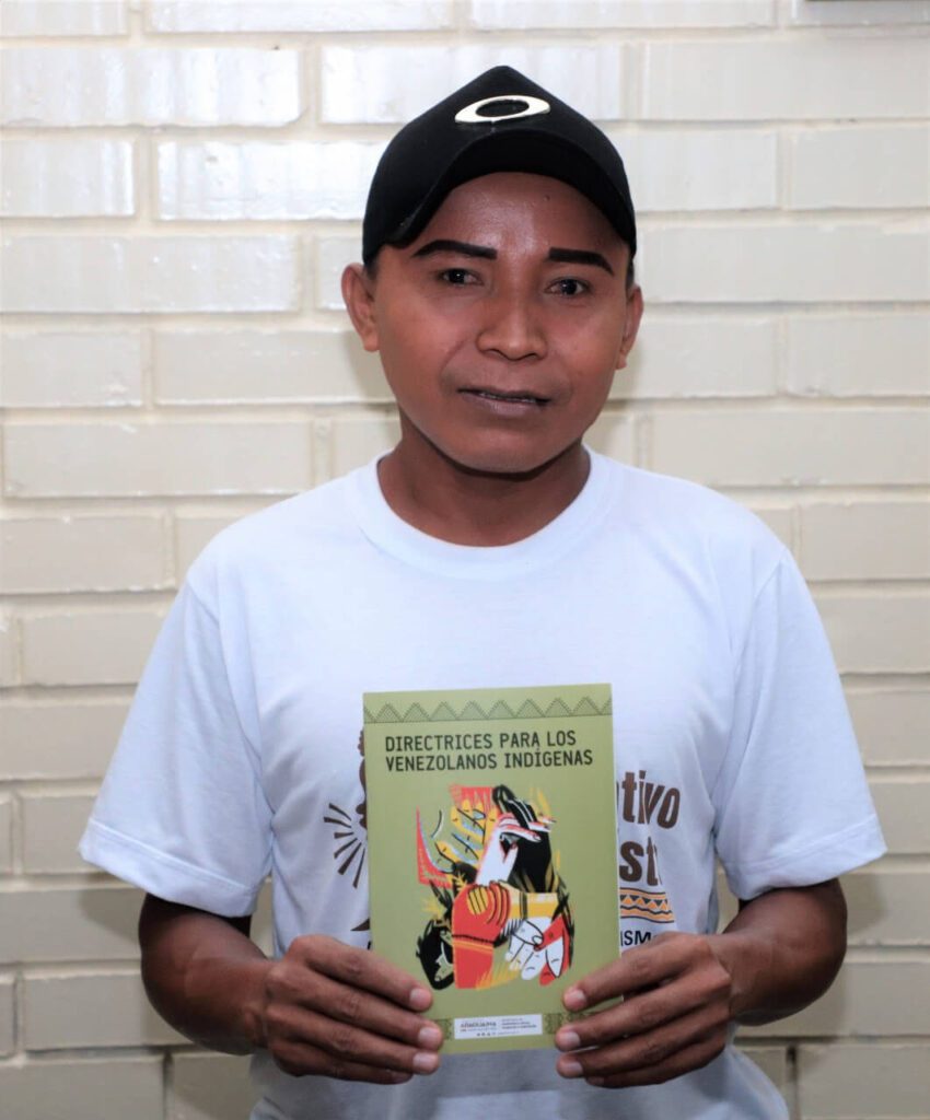 Venezuelano segurando guia de direitos dos imigrantes